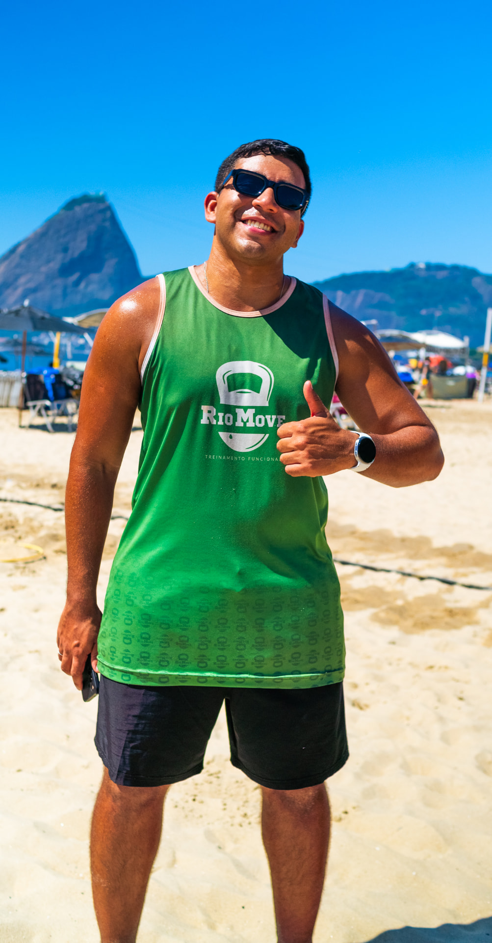 Professor da RioMove na praia, com o Pão de Açúcar ao fundo